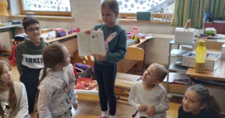 Kinder präsentieren ein Buch